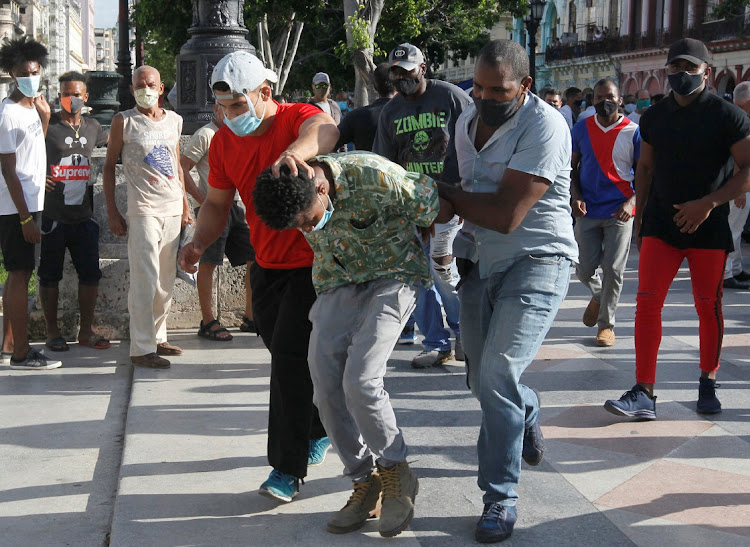 Plain clothes police detain a person during protests against and in support of the government, amidst the coronavirus disease (Covid-19) outbreak, in Havana, Cuba July 11, 2021.