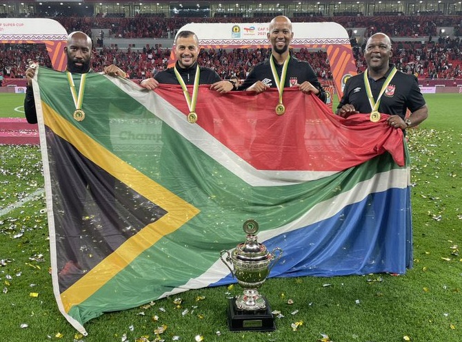 Al Ahly coach Pitso Mosimane (right) and his technical team, fitness trainer KB Rangoaga (left), assistant coach Samy Komsan (second left) and performance analyst Musi Matlaba, with the Caf Super Cup trophy after their team's penalty shootout win over Raja Casablanca at Ahmed bin Ali Stadium in Al Rayyan, Qatar.