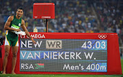 South Africa's Wayde van Niekerk poses by the results board after he broke the world record in the Men's 400m Final during the athletics event at the Rio 2016 Olympic Games at the Olympic Stadium in Rio de Janeiro on August 14, 2016.