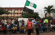 Demonstrators gather on the street to protest against alleged police brutality, despite a round-the-clock curfew imposed by the authorities on the Nigerian state of Lagos, Nigeria on October 20 2020. 
