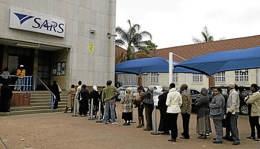 File photo of people queuing to submit their income tax returns to SARS.