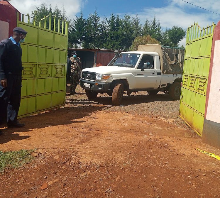 A police vehicle carrying the body from the home