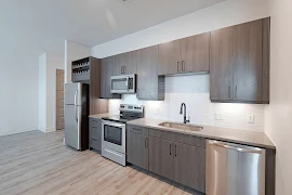 Kitchen with modern style cabinetry, stainless steel appliances, and wine rack above refrigerator