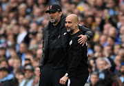 Liverpool manager Jurgen Klopp and Manchester City counterpart Pep Guardiola share a joke during the Premier League match at Etihad Stadium in Manchester, England on April 10 2022.