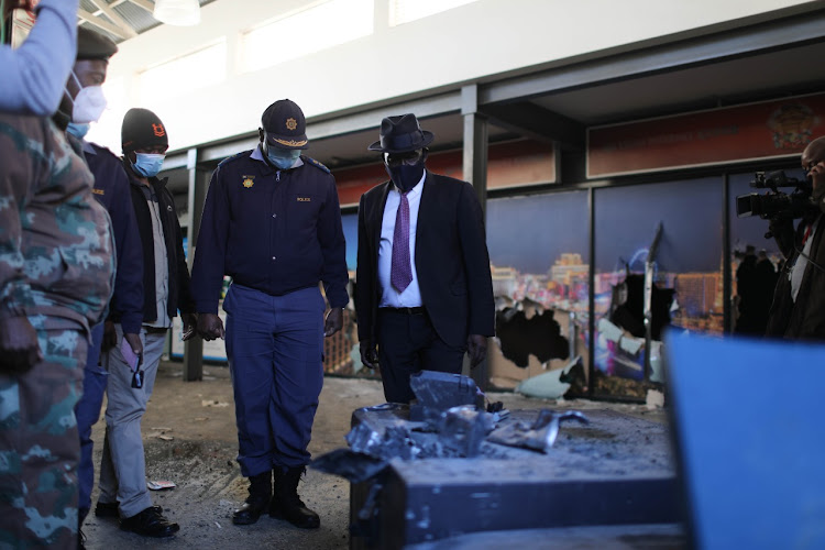 The minister of police Bheki Cele inspects a broken ATM safe, 13 July 2021, in Alexandra, Johannesburg. Calm was restored to the area following the deployment of the army.