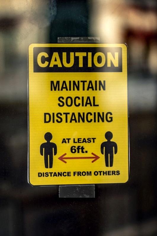  A sign that reads “caution, maintain social distancing – at least 6ft. distance from others”.