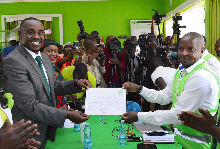 Kakamega Senator Cleophas Malala and his running mate Beatrice Inyangala receiving the clearance certificate from Kakamega county IEBC returning officer Joseph Ayatta on Tuesday