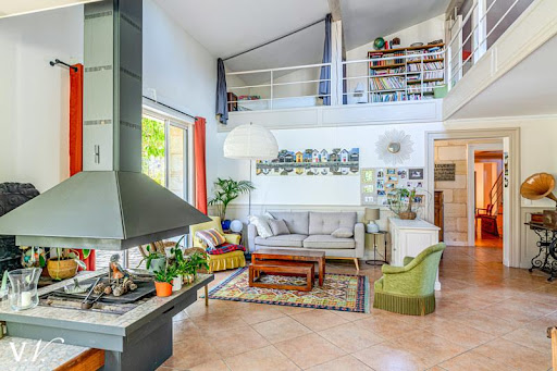 Living room with mezzanine and central fireplace in this luxury property for sale in Bordeaux ($1,937,638 - 300 m²)