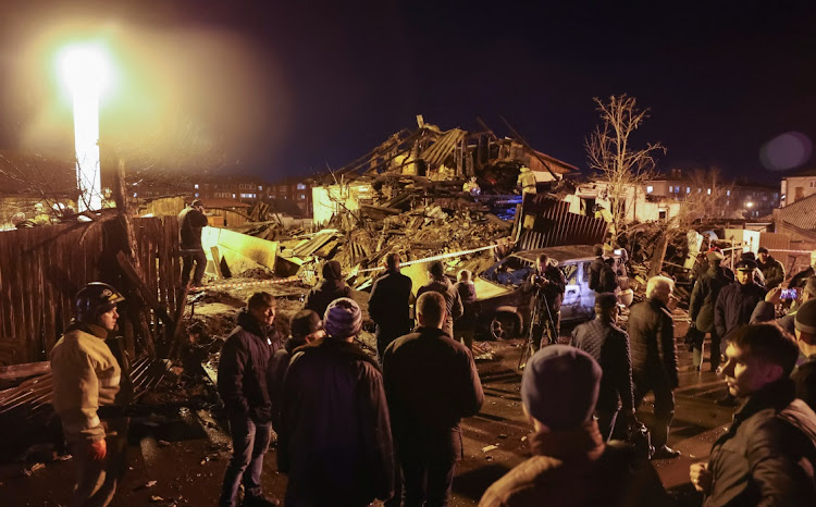 People view the site where a military jet crashed into a residential building in the city of Irkutsk, Russia, October 23 2022. Picture: REUTERS