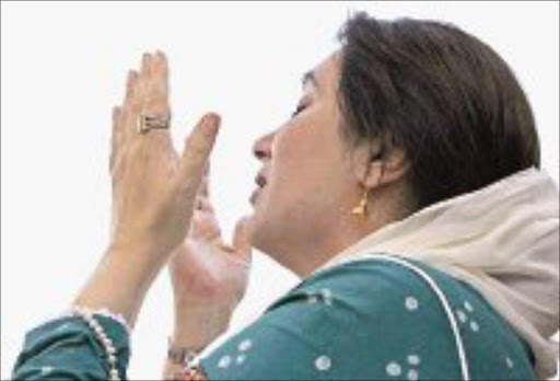 HOME: Benazir Bhutto prays as she arrives in Karachi. Pic. Petr Josek. 18/10/07. © Reuters.