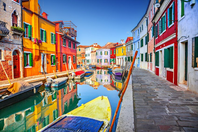 The island of Burano, Italy, is known for its lovely canals edged by brightly painted houses.