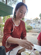 Nini Zhao serving freshly brewed tea.