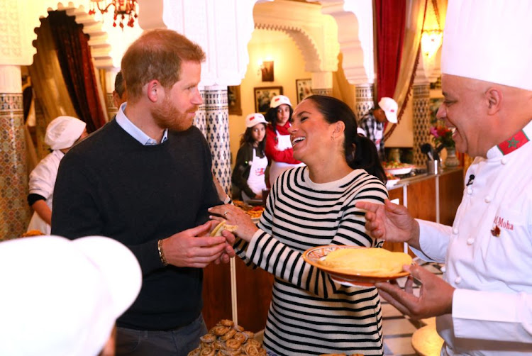 Prince Harry and Meghan, Duchess of Sussex, share a joke during a cooking demonstration in Rabat, Morocco.