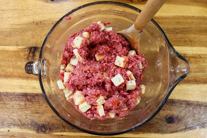 Combine Ground Beef, Buffalo Sauce, And Cubed Pepper Jack Cheese.