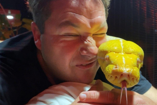 SA conservationist Dingo Dinkelman with a reticulated python in the cage where he spent five nights.