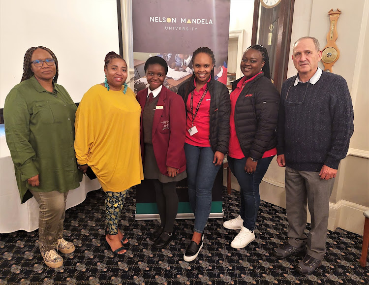 Prof Werner Olivier, director of Nelson Mandela University’s Govan Mbeki Mathematics Development Centre (GMMDC), with Isuzu Motors SA’s Anovuyo Tshemese, third from right, and Iviwe Poti, second from right, share their plans to support matric maths classes with Ethembeni Enrichment Centre's staff and pupils, including, from left, grade 12 teacher Noluthando Jakavula, principal Nobatembu Mandimo and grade 12 pupil Emihle Maqungo