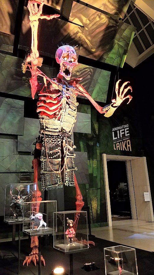 At the Laika exhibit at the Portland Art Museum, this display shows how Laika scaled the giant skeleton (here 18 feet, which is 1/5 scale of the 90 feet in human scale the monster is in the story) to the average height of the other characters Kubo (9.25 inches), Monkey (13 inches), Beetle (21 inches), and Hanzo Origami (2 inches).