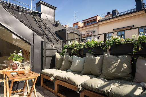 Terrace with bench and green cushions in this luxury apartment for sale in Stockholm (101 m²)