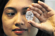 An employee holds a 118.28 carat, flawless D Color Magnificent Oval Diamond at Sotheby's auction house in New York this week. First discovered in deep mines in Southern Africa and chiselled from a huge 299 carat rough, the gem is expected to fetch between $28-million and $35-million at an auction in Hong Kong on October 7.