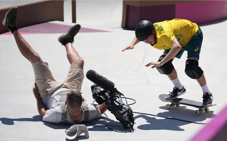 Keegan Palmer (R) of Australia clashes into a cameraman during the men's park heat of skateboarding at the Tokyo 2020 Olympic Games in Tokyo, Japan, August 5, 2021