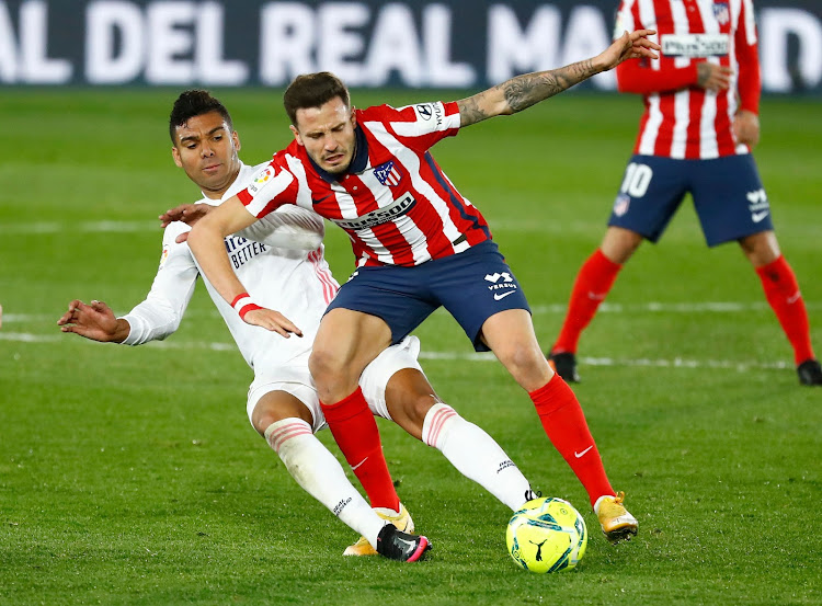 Real Madrid's Casemiro in action with Atletico Madrid's Saul Niguez