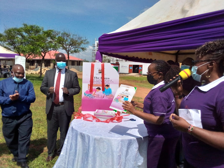 Dr. Caroline Mwangi cutting ribbon during the launch of the scale up plan in Bungoma County and Bungoma county chief officer for sanitation Patrick Wandili (in red tie).