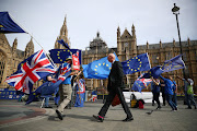 Anti-Brexit demonstrators wave flags outside the Houses of Parliament, in London, UK, on Monday.