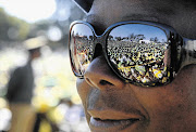 Supporters of Zimbabwean President Robert Mugabe's Zanu-PF reflected in sun-glasses at an election rally in Marondera yesterday