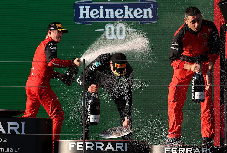 Ferrari's Charles Leclerc celebrates on the podium with Mercedes' George Russell