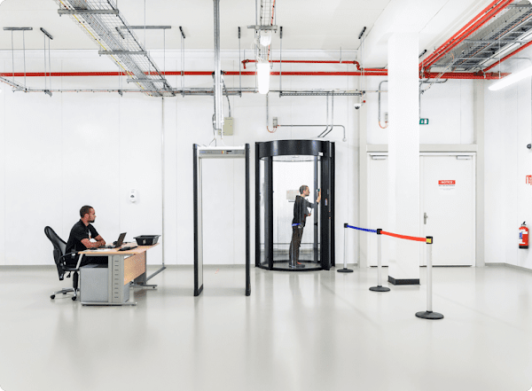 Interior de un centro de datos de Google Cloud. Hay un guardia de seguridad y otra persona que entra por una puerta que requiere superar varios protocolos de seguridad.