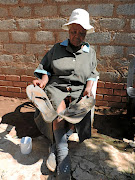 Pensioner Winnie Mokoena shows  the sandals  left behind by the alleged killer of her adult children. 