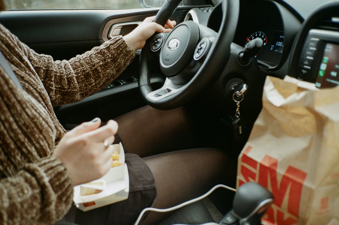 Free Man in brown long-sleeved shirt driving and eating Stock Photo