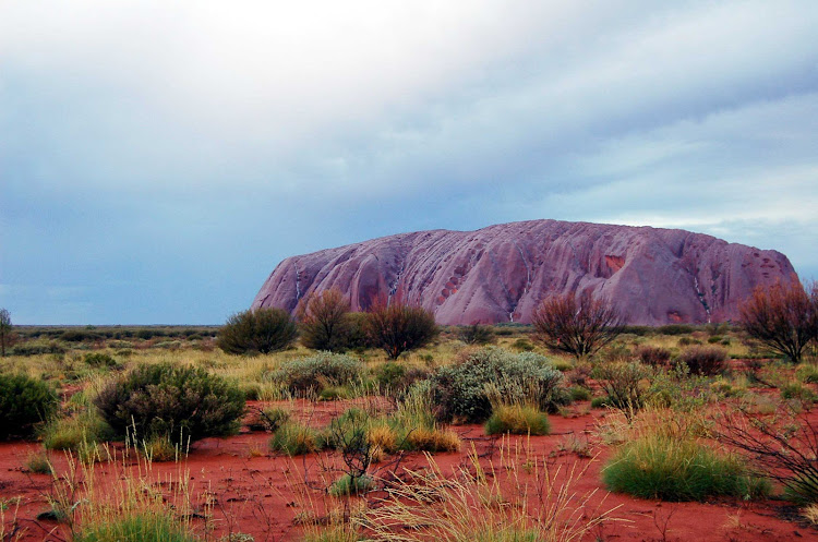 A colorized view of Uluru, or Ayers Rock, under the rain in Australia's  Northern Territory. 