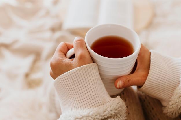 Young woman holding a cup of tea while enjoying the winter holidays Free Photo