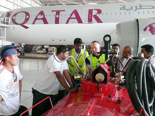 A Qatar Airline plane anchored at the hanger for service.