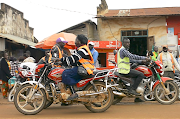 Congolese motorbike taxi rider Imelda Mmambu rides her motorbike as she waits for potential clients along the streets of Beni, in eastern Democratic Republic of Congo on August 31 2020. 
