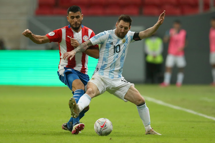Junior Alonso of Paraguay competes for the ball with Lionel Messi of Argentina during a Group A match of the Copa America at Mane Garrincha Stadium on June 21, 2021 in Brasilia