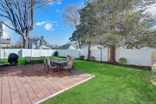 Paved patio and fenced green backyard - Buy this luxury house in Massapequa, 4 bedrooms