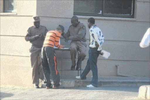 NOT BUSINESS AS USUAL: Parole officers in the Johannesburg CBD have been working from the pavement for the past three weeks after their offices were locked due to unpaid rent. PHOTO: BUSISIWE MBATHA