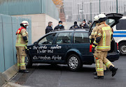 Firefighters remove the car which crashed into the gate of the main entrance of the chancellery in Berlin, the office of German Chancellor Angela Merkel in Berlin, Germany, November 25, 2020. Letters written on the car read: 