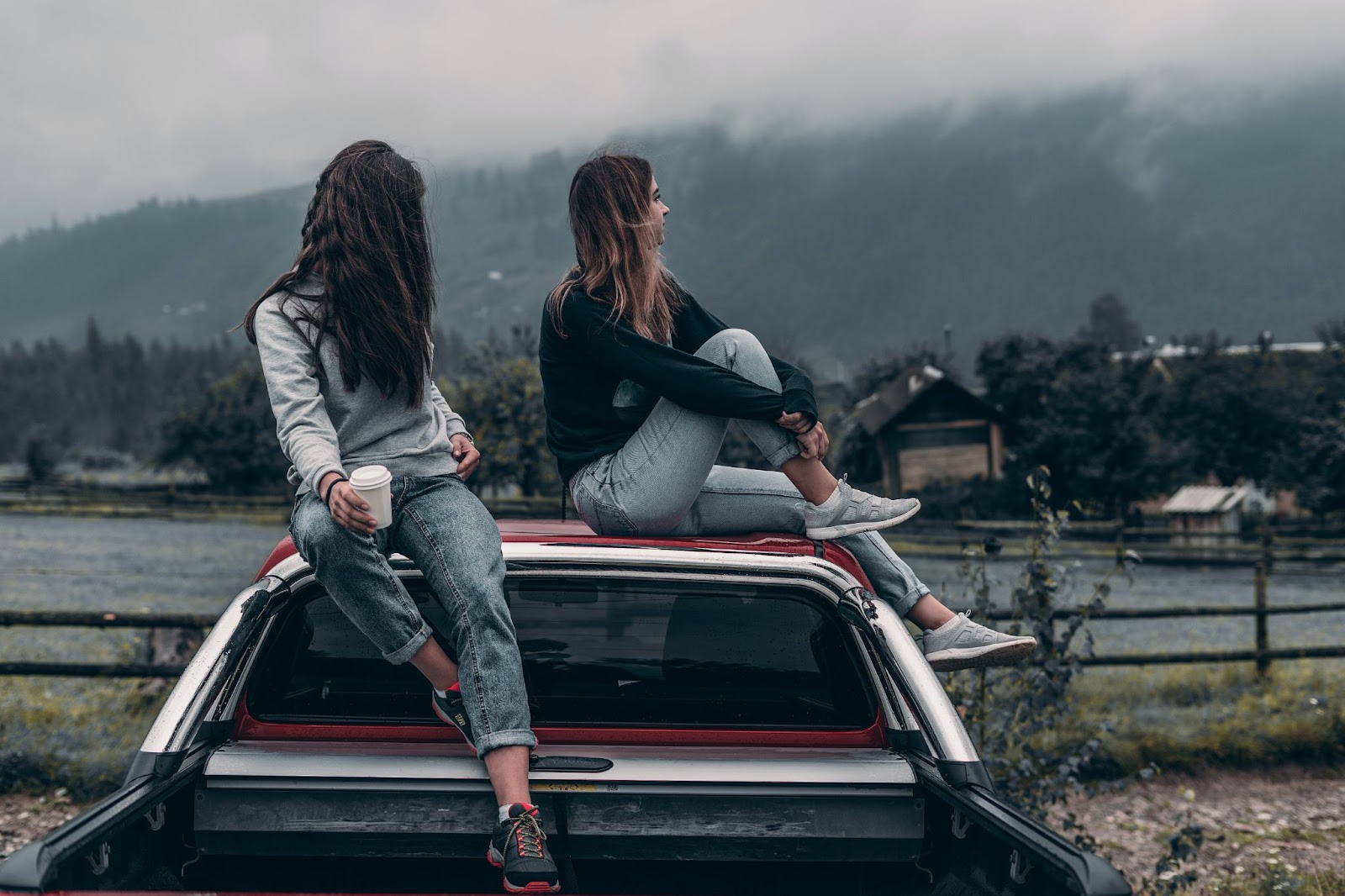 Two women sitting on a red vehicle