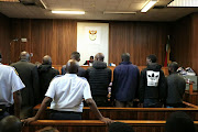 The seven men accused of being behind the daring cash heist at OR Tambo International  Airport together in court for the first time as two police officers look on. Picture: Kyle Cowan