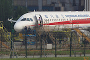 Workers inspect a Sichuan Airlines aircraft that made an emergency landing after a windshield on the cockpit broke off, at an airport in Chengdu, Sichuan province, China May 14, 2018. 