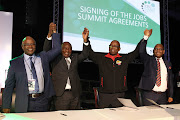 Sipho Pityana,President Cyril Ramaphosa, Bheki Ntshalintshali and Thulani Tshefuta hold hands after  signing the Job summit frame work agreement in Midrand on October 4 2018