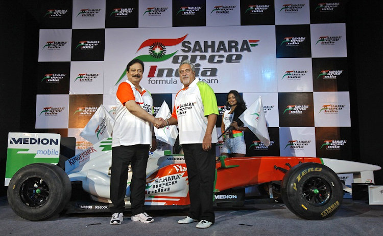 OFF THE RAILS: Vijay Mallya, right, co-owner of the Force India Formula One team, and Sahara Group chairman Subrata Roy shake hands in New Delhi in 2011. Roy has been in jail since March 2014 when the Securities and Exchange Board of India said two of his companies had defrauded investors of $4bn. Picture: REUTERS/ADNAN ABIDI