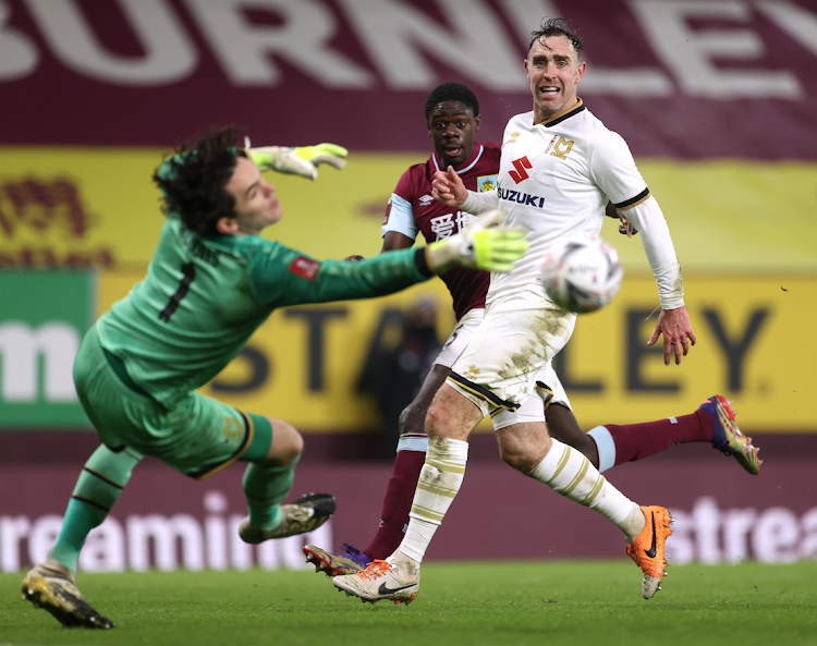 Burnley's Joel Mumbongo in action with Milton Keynes Dons' Richard Keogh and Lee Nicholls