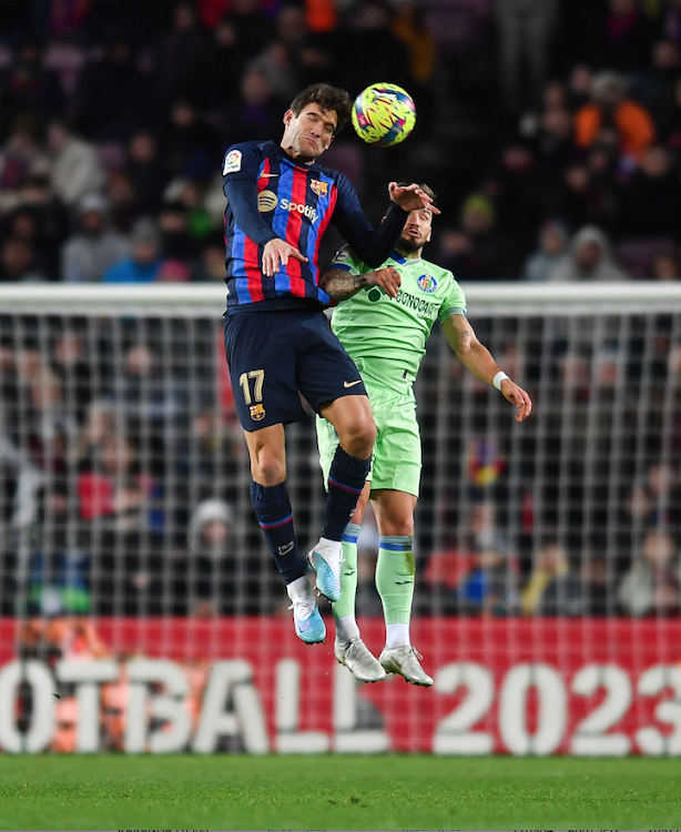 Barcelona's Marcos Alonso (L) vies for the ball with Portu of Getafe during a Spanish La Liga match January 22