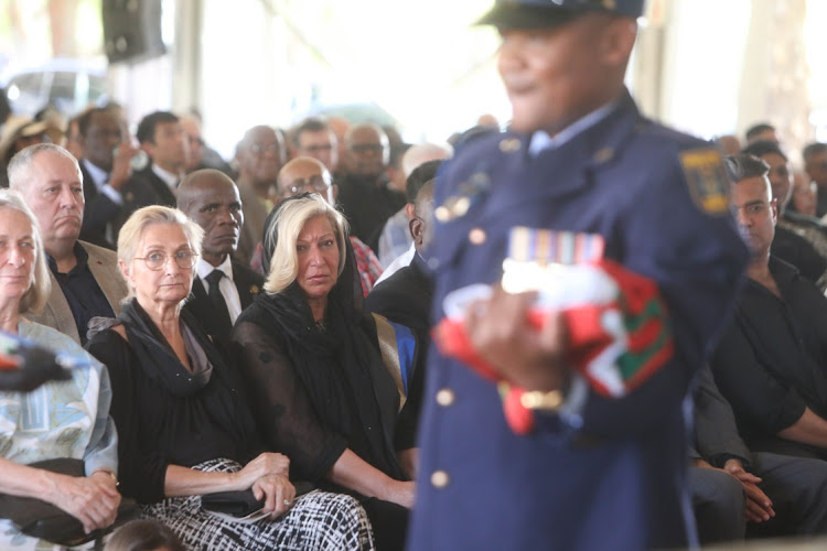 Aziz Pahad’s wife Angina watches as members of the police remove a South African flag from his coffin at Westpark Cemetery during his state funeral.