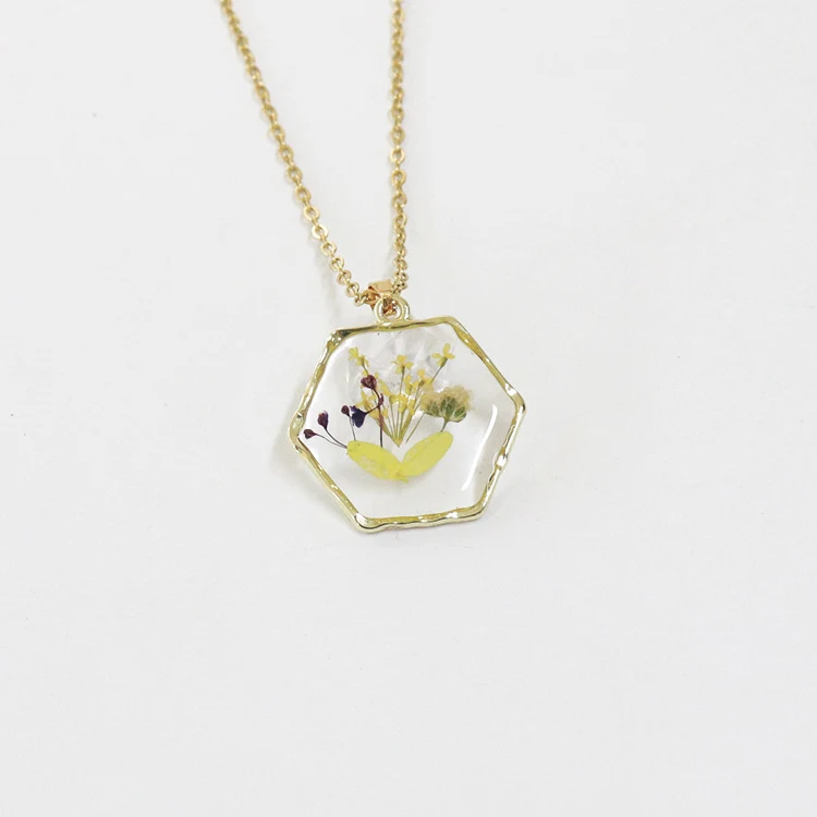 Polygon-Halskette mit konservierten Blüten und Trockenblumen. Einzigartiger, langlebiger und stilvoller Schmuck. Perfekt als Geschenk.