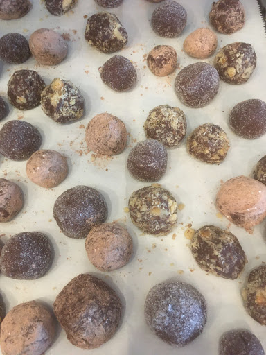 Rum balls.  Dusted with chopped walnuts, some with powdered sugar/cocoa and others with sugar.